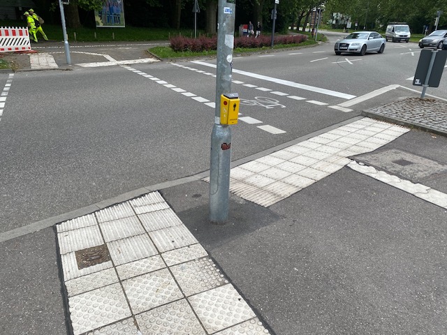 Am Kreisverkehr führt das Leitsystem zum Ampelmast mit dem Betätigungsknopf Der Auslöser für die Sprachansage der Ampelanzeige befindet sich an der Unterseite des Befehlsgeräts